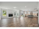 Open-concept living room featuring a fireplace and a view of the kitchen and backyard at 3253 Mcharney Dr # 27, Harrisburg, NC 28075