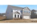 This home features a light gray color, a grey shake accent, and a two-car garage at 121 Saidin Ln, Troutman, NC 28166