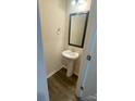 Cozy powder room with a pedestal sink, modern mirror, and beautiful flooring at 3933 Townes Blvd, Terrell, NC 28682