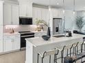 Modern kitchen with white cabinetry, stainless steel appliances, an island with a quartz countertop, and bar stool seating at 459 Blairhill Rd # 02, Charlotte, NC 28217