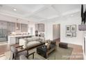 Open-concept living room showcasing a modern kitchen, coffered ceilings, and hardwood floors at 1228 Sage Pine Cir # 12, Clover, SC 29710