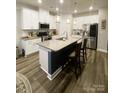 Modern kitchen featuring white cabinets, a large island, and stainless steel appliances at 3524 Tully Ave, Kannapolis, NC 28081
