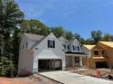 Two story home with white siding, gray stone accents, and a two-car garage at 3245 Mcharney Dr # 28, Harrisburg, NC 28075