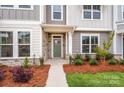 Townhome entrance with green door, stone accents, and landscaping at 10511 Boudreaux St, Huntersville, NC 28078