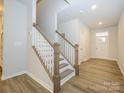 Modern staircase with wood and white railings in a light-filled entryway at 10511 Boudreaux St, Huntersville, NC 28078