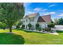 Well-maintained two-story home with a lush green lawn and manicured landscaping in a residential neighborhood at 7876 Rebecca Rd, Denver, NC 28037