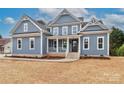 Charming two-story home with a welcoming front porch, light blue siding, and white trim at 332 Canvasback Rd, Mooresville, NC 28117