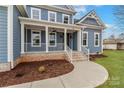 Stunning home exterior showcasing the inviting front porch and professional landscaping around the property at 332 Canvasback Rd, Mooresville, NC 28117