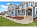 Eye-catching blue exterior with a covered porch, brick accents, and a sidewalk leading to the entrance at 332 Canvasback Rd, Mooresville, NC 28117