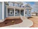 Charming blue two-story home with a welcoming front porch and well-maintained landscaping at 332 Canvasback Rd, Mooresville, NC 28117