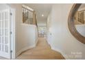Bright hallway featuring hardwood floors, a staircase with iron railings, and an elegant round mirror at 225 English Arbor Dr # 13, Fort Mill, SC 29715