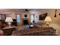 Cozy living room featuring a stone fireplace, ceiling fan, and comfortable furniture at 102 Cedar Hollow St, Fort Mill, SC 29715