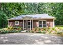 Brown house with white trim, gravel driveway, and landscaped yard at 120 Zorse Ln, Statesville, NC 28625