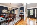 Elegant dining room with hardwood floors, a chandelier, and dark blue walls at 2594 Knoll Ridge Ct, Hickory, NC 28602