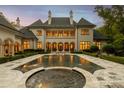 Expansive backyard featuring a luxurious pool with fountain features and an elegant terrace at 423 Oakmont Ln, Waxhaw, NC 28173