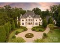 Elegant home showcasing manicured grounds, a circular driveway, and lush landscaping at 423 Oakmont Ln, Waxhaw, NC 28173