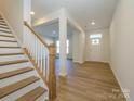 Bright entryway with hardwood floors, staircase, and open view to living room at 10509 Boudreaux St, Huntersville, NC 28078