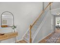 Modern staircase with wooden handrail and light walls at 11407 Sidney Crest Ave, Charlotte, NC 28213
