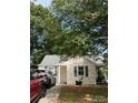 Cottage-style home with neutral siding, green shutters, and a well-maintained front yard with mature trees at 3329 Draper Ave, Charlotte, NC 28205
