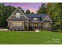 Inviting home with manicured lawn, dormer windows, and covered porch, ideal for relaxing evenings at 859 Irish Creek Dr, Landis, NC 28088