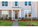 Townhouse front entrance with dark door, stone accents, and landscaping at 10513 Boudreaux St, Huntersville, NC 28078