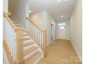 Light-filled entryway with hardwood floors and a wooden staircase at 10513 Boudreaux St, Huntersville, NC 28078