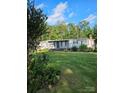 Mobile home with a grassy yard and trees at 735 Ned Marsh Rd, Salisbury, NC 28146