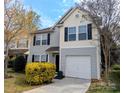 Charming two-story home with gray siding, black shutters, lush landscaping, and a convenient one-car garage at 1327 Phil Oneil Dr, Charlotte, NC 28215