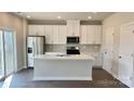 Modern kitchen featuring white cabinets, stainless steel appliances, granite countertops and a large island at 158 Shepherds Landing Dr, Mooresville, NC 28115