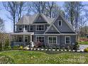 Inviting two-story home with a covered front porch, manicured lawn, and mature trees at 837 Lake Forest Dr # Nottingham, Belmont, NC 28012