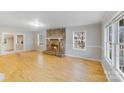 Bright living room with hardwood floors and a stone fireplace, perfect for cozy evenings at 2515 Winterfield Dr, Gastonia, NC 28056