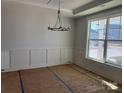 Formal dining room with elegant chandelier, wainscoting, and large window that offers natural light at 3229 Mcharney Dr # 30, Harrisburg, NC 28075