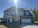 Beautiful two-story home featuring a stone accent wall, covered porch, and an attached two-car garage at 3229 Mcharney Dr # 30, Harrisburg, NC 28075