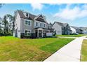 View of a well-manicured lawn and sidewalk running in front of modern two-story homes at 3229 Mcharney Dr # 30, Harrisburg, NC 28075