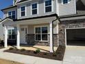 Inviting front porch featuring stone accents, white columns, and manicured landscaping leading to the main door at 3229 Mcharney Dr # 30, Harrisburg, NC 28075
