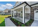 Covered front porch with stone accents and manicured landscaping at 3229 Mcharney Dr # 30, Harrisburg, NC 28075