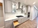 Modern kitchen with gray cabinets, stainless steel appliances, and a white herringbone backsplash at 9653 Liberty Hill Dr, Mint Hill, NC 28227