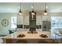 Modern kitchen featuring white cabinets, stainless steel appliances, a center island with a sink, and pendant lighting at 2630 Rose St, Charlotte, NC 28208