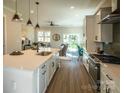 Open kitchen with white cabinets, quartz countertops, stainless steel appliances, and seamless flow to the living area at 2630 Rose St, Charlotte, NC 28208