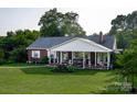 Attractive one-story brick home with a wide covered porch and well-kept yard, showcasing classic charm at 3021 Davis Park Rd, Gastonia, NC 28052