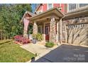 Inviting front porch with stone columns and landscaping at 12528 Generations St, Charlotte, NC 28278