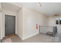 Hallway with a door, fire extinguisher, and carpeted stairs at 2423 Vail Ave # A12, Charlotte, NC 28207