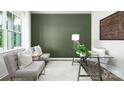 Home office with glass desk, two chairs, and green accent wall at 3925 Coleman Dr, Charlotte, NC 28215