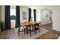 Modern dining room with hardwood floors, a wood table, and black chairs at 5211 Reedy Ridge Rd, Charlotte, NC 28215