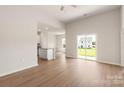 Open-concept living room with wood-look flooring, sliding glass doors, and a view of the kitchen island at 3607 Clover Valley Dr, Gastonia, NC 28052