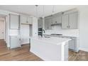 Modern kitchen featuring gray cabinets, white countertops, stainless appliances, and a central island with sink at 97 Seven Oaks Lndg, Belmont, NC 28012