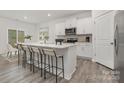 Modern kitchen features white cabinets, stainless steel appliances, and a spacious island with bar seating at 104 Rustling Waters Dr, Mooresville, NC 28117