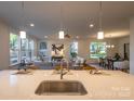 Modern kitchen island with sink and seating overlooking living room at 621 Seldon Dr, Charlotte, NC 28216