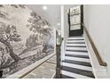 Elegant entryway with wood floors, stairway, striking wallpaper and modern geometric carpet, creates a welcoming ambiance at 3016 Endhaven Terraces Ln # 11, Charlotte, NC 28277