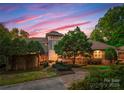 Beautiful single-Gathering home with manicured landscaping, stone accents, and lush greenery in a serene neighborhood at 10310 Wildlife Rd, Charlotte, NC 28278